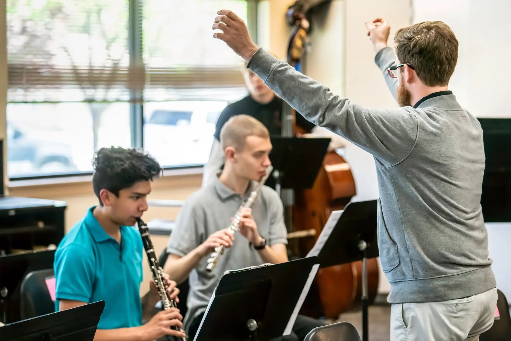 band director conductor and high school flutist and clarinetist playing music