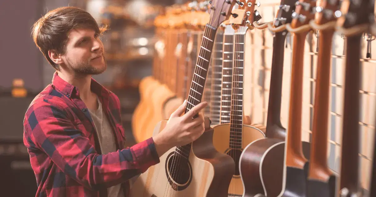 Shopper at a musical instrument shopping browsing acoustic guitars