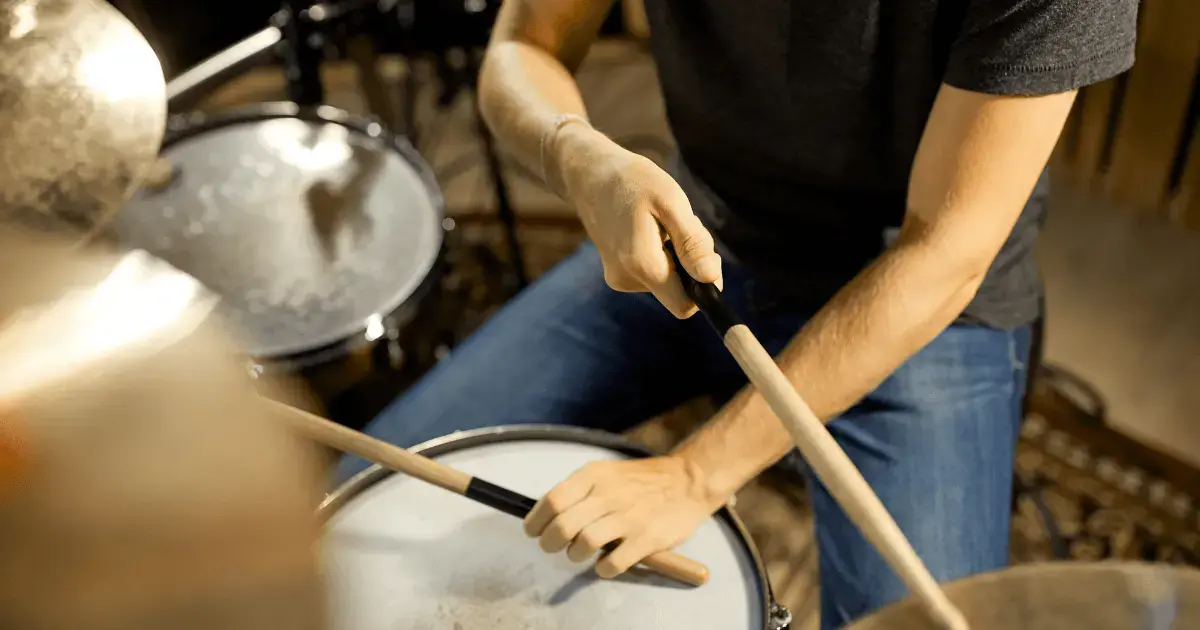 man using the drums in a music shop